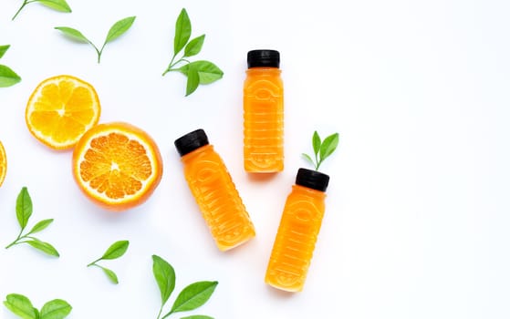 Orange juice in plastic bottles with orange fruit on white background.