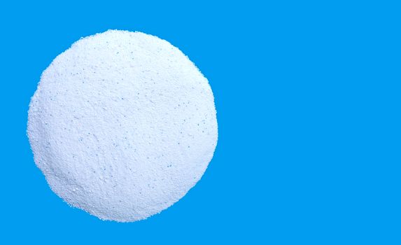 Washing powder pile on blue background. Copy space