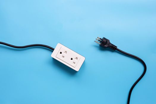 Electrical power strip and plug on blue background. Top view