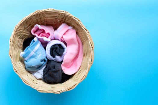 Laundry basket with socks on blue background. Copy space