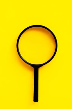 Magnifying glass on yello background. Top view