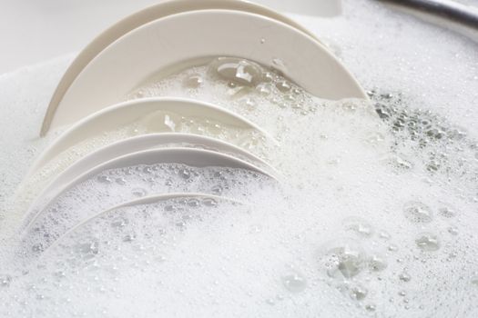 Dish washing, Dirty dishes soaking in kitchen sink.