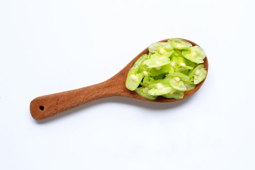 Moringa oleifera seeds on wooden spoon isolated on white background.