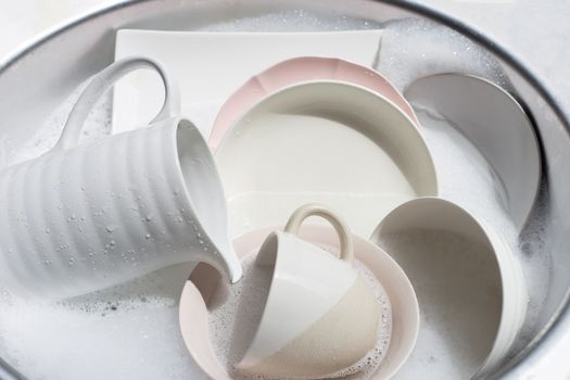 Dish washing, Close up of utensils soaking in kitchen sink. 