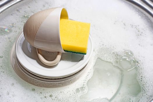 Dish washing, Dirty dishes with cup soaking in kitchen sink.