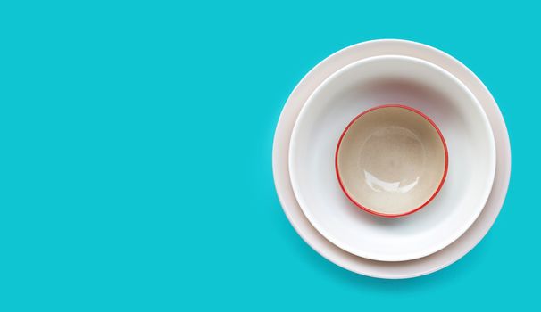 Stack of dish and bowl on blue background. Copy space