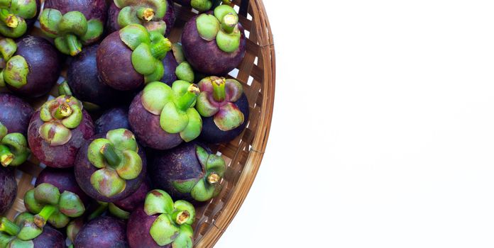 Mangosteen in wooden bamboo threshing basket on white background. Copy space