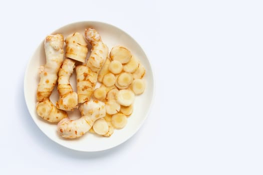 Fresh galangal on dish plate isolated on white background.