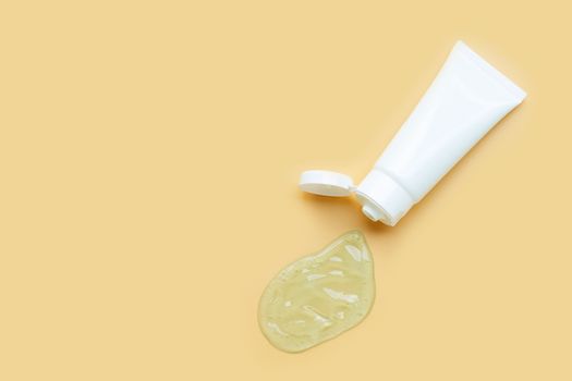 Alcohol hand sanitizer gel in white glossy plastic tube for hygiene corona virus (Covid-19) protection. Yellow background with copy space