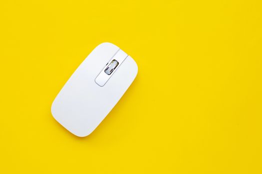 White computer mouse on yellow background. Copy space