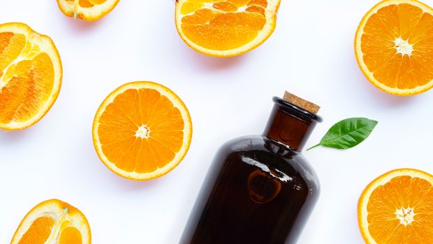 Natural orange essential oil on white background. Top view