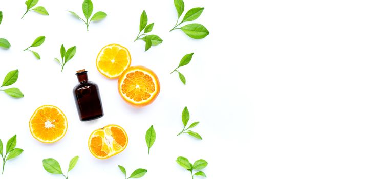 Fresh orange fruit and leaves with essential oil bottle on white background. Copy space