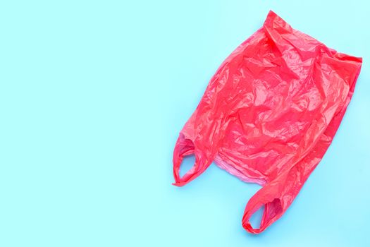 Red plastic bag on blue background. Copy space