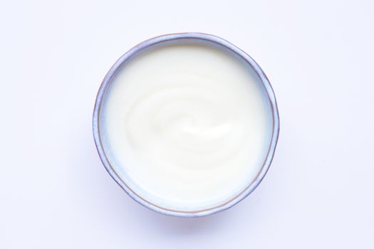 White yogurt in bowl on white background. Top view