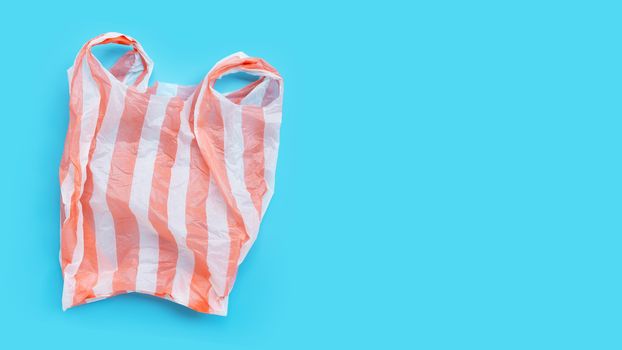 Colorful plastic bag on blue background. Copy space