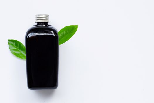 Essential oil bottle with green leaf on white background. Copy space