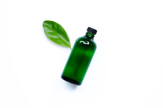 Essential oil bottle with green leaf on white background. Copy space