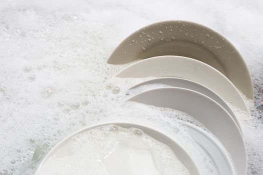 Dish washing, Dirty dishes with cup soaking in kitchen sink.