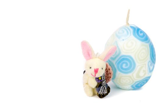 cute little handmade bunny and a white and blue easter candle egg isolated on white background with copy space