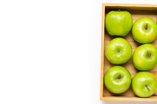 Ripe green apples in wooden box on white background. Copy space