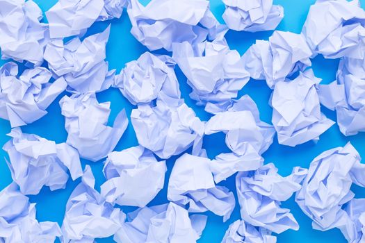 Crumpled paper balls on a blue background. Top view