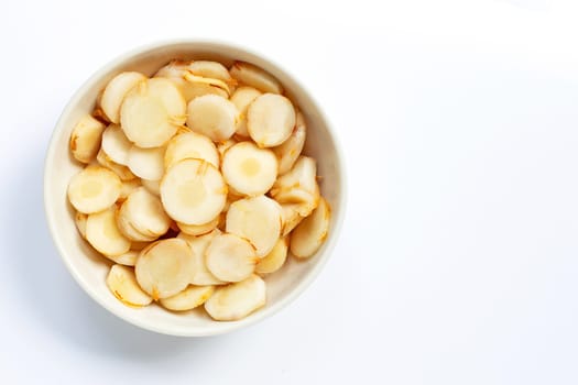 Fresh galangal slices in white bowl isolated on white background.