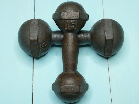 closeup image of a pair of metal dumbbells on wooden background. Exercise concept.