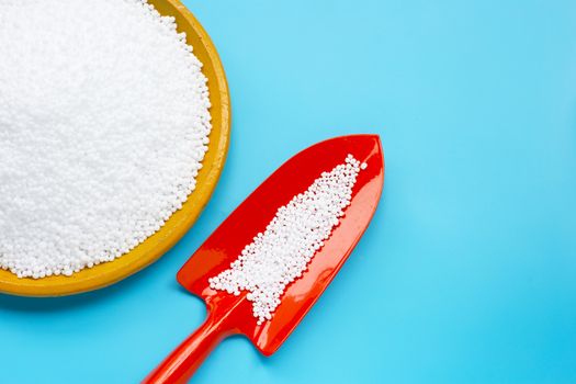 Chemical plant urea fertilizer on blue background. Copy space