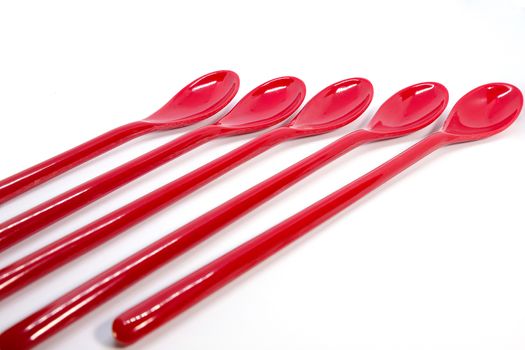 red plastic spoons, isolated on white background
