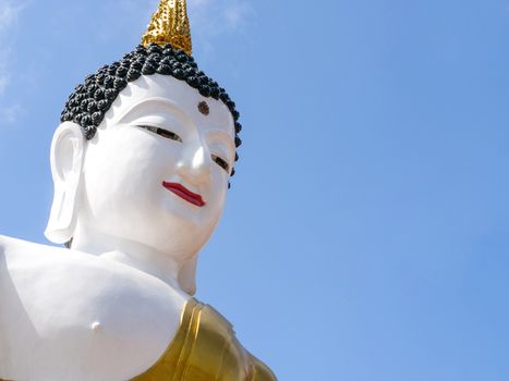 A huge white painted buddha statue is on public display outdoor, This iconic figure is in Chiang Mai City, Thailand. Isolated sky background