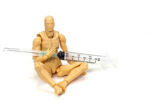 a plastic model holding a needle and a syringe in his hands, drug use or dependent concept, on white background