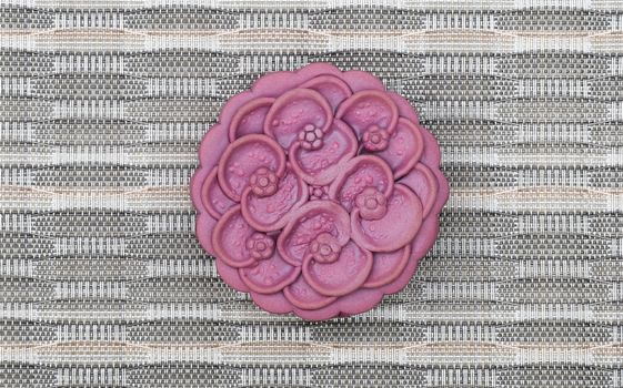 Purple japanese yam moon cake, top view, light brown background