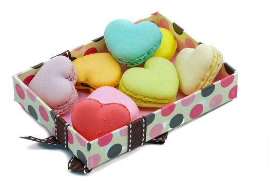 assortments of pastel color macaroons, on a gift box, isolated on white background