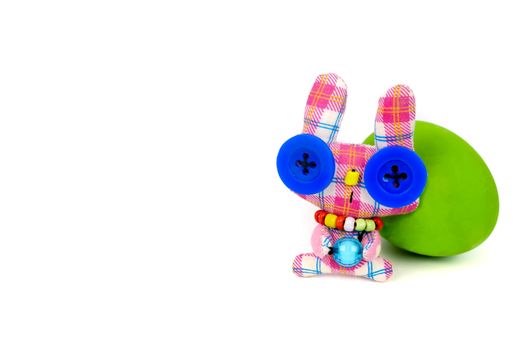 comical little handmade bunny rabbit and a green easter egg isolated on white background with copy space