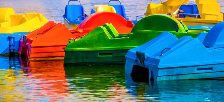 Abstract shot, colored reconstruction in water, pedal boats, red, yellow, green, blue