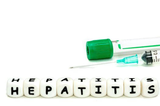 A laboratory test tube and a syringe for blood sampling in the patient. The alphabet letters hepatitis emphasize the awareness of this serious condition. Macro image on white background.