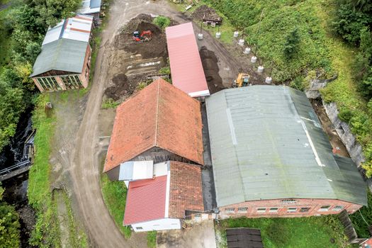 Renovation of old factory buildings from the 19th century, aerial view, with forest in the background