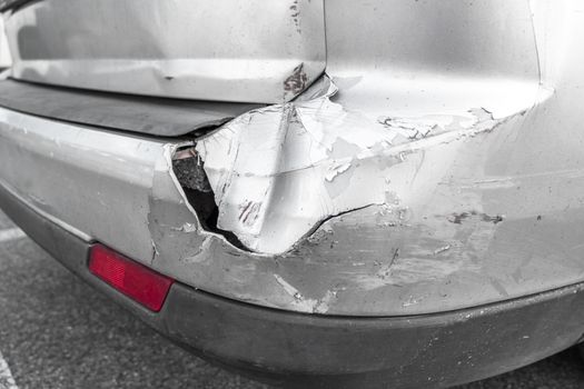 Back of gray car get damaged from accident on the road. Vehicle bumper dent broken by car crash. Road accidents.