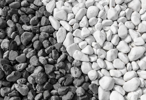 Background of black and white pebbles. The stones lie side by side.