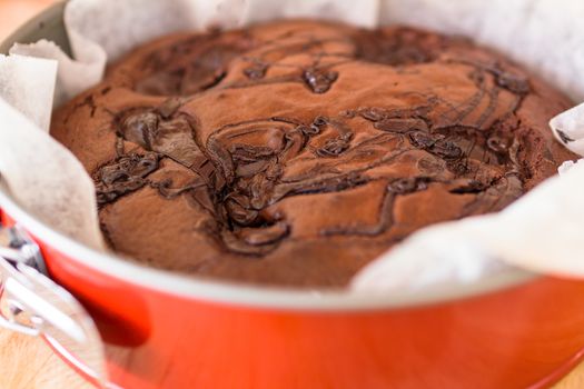 Close Up of round delicious cocoa cake, sprinkled with melted chocolate. The dessert is freshly baked. Selective focus