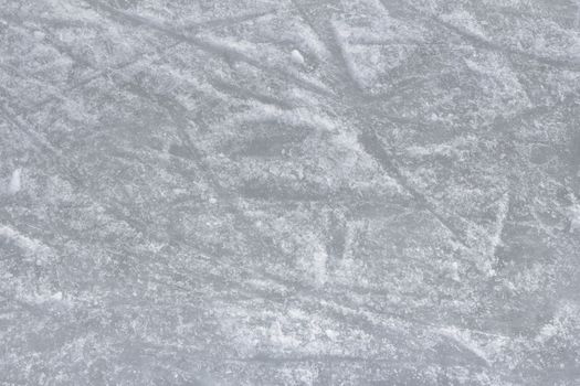 Close up of white ice surface with a traces left by the skates. Ideal for texture and backgrounds.