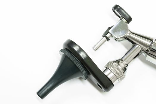 an otoscope, made of stainless steel, an important tool used by a otolaryngologist, or an ear doctor, to examime a patient's ear, isolated on white backgrown, closeup view