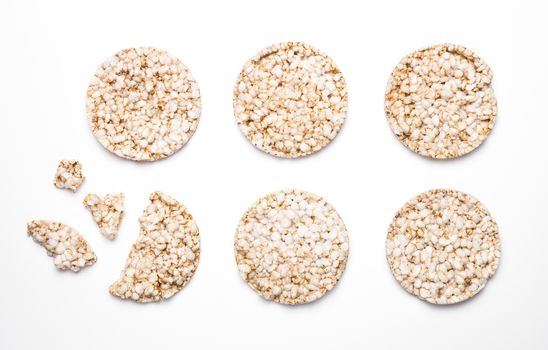 Six rice and spelled cakes isolated on white. One is broken. Concept of healthy eating and diet.