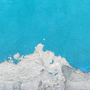 Fragment of wall with broken stucco. Old azure wall with damaged shabby color plaster. Distressed wall background. Concept of renewal, of restore and repair.