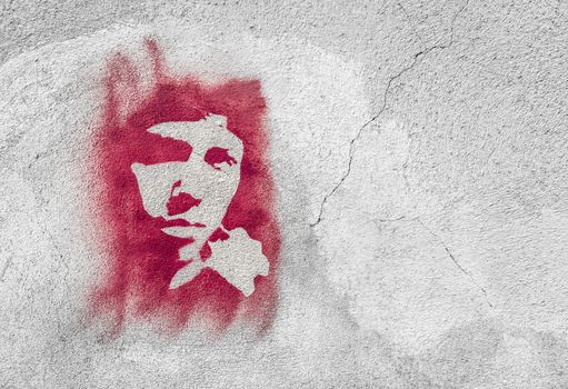 Red face on wall. Stencil graffiti.