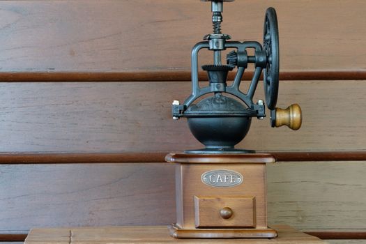 a vintage coffee grinder on a small wooden table