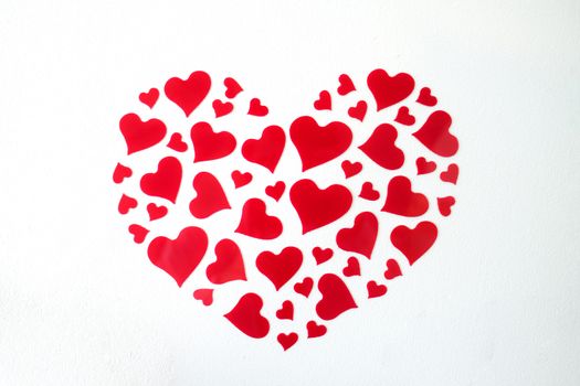 image of red heart shaped paper on a white concrete wall, love, heart, romance concepts