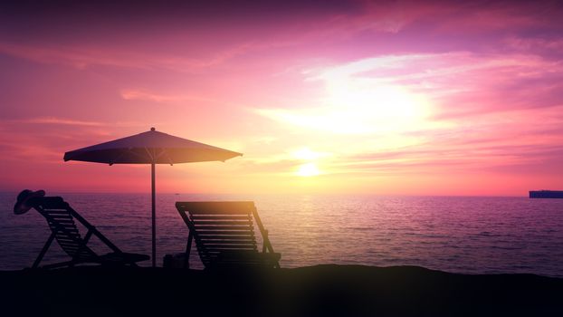 Silhouettes of empty deckchairs and beach umbrella against the backdrop of the setting sun in the ocean.