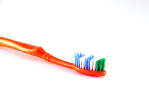 Orange toothbrush over white