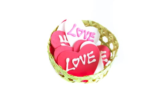 a piles of sugary heart-shaped love signs in a small handmade bamboo busket, isolated on white background, Valentines' Day, love, romance, gift, concept